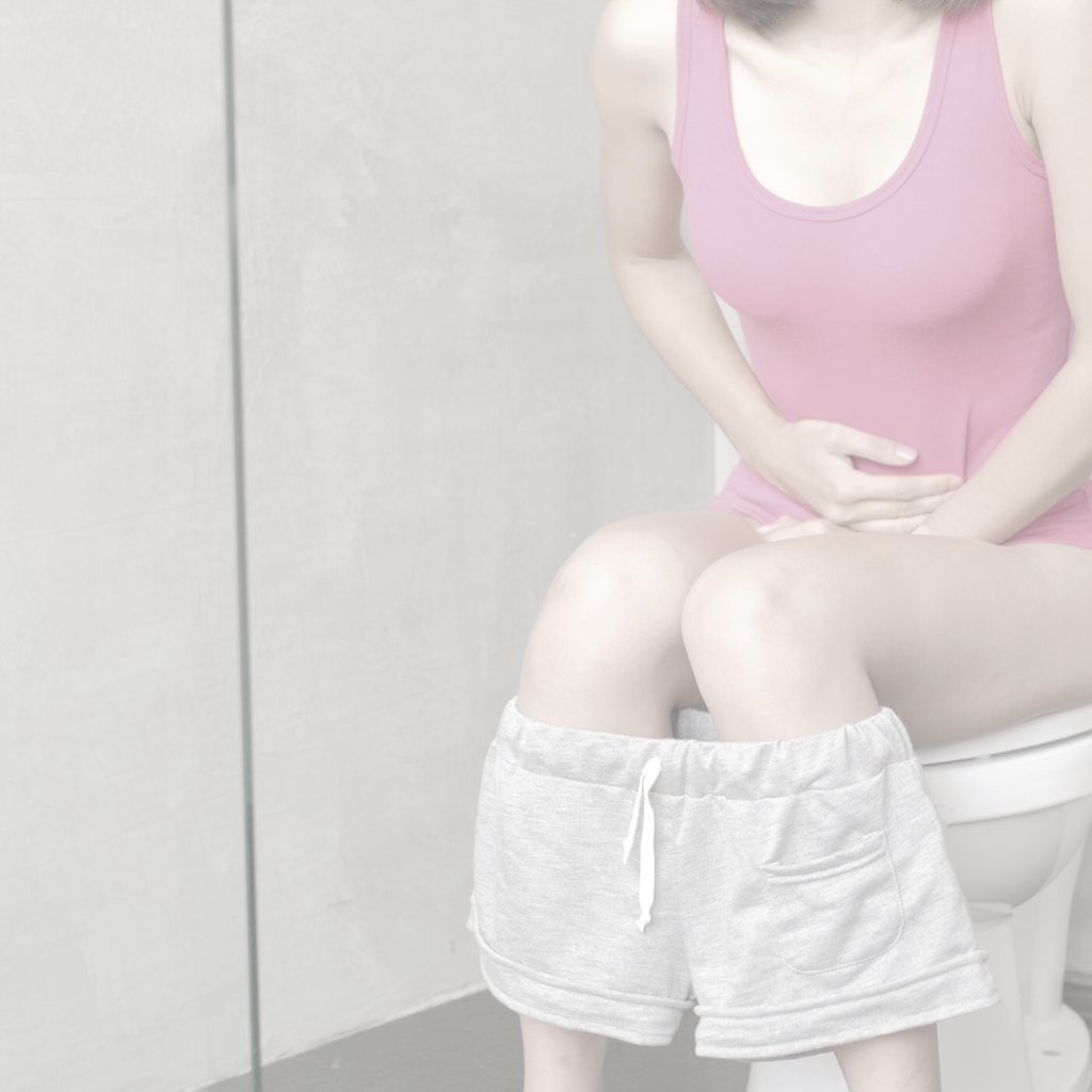 Chlamydien: Frau sitzt auf der Toilette und hält sich den Bauch