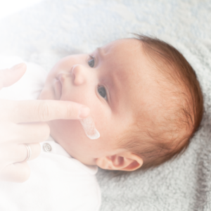 Wange eines Babys wird eingecremt