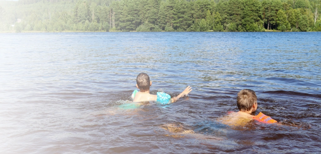 Kinder schwimmen im See