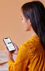 Frau hält Smartphone mit Website von OnlineDoctor